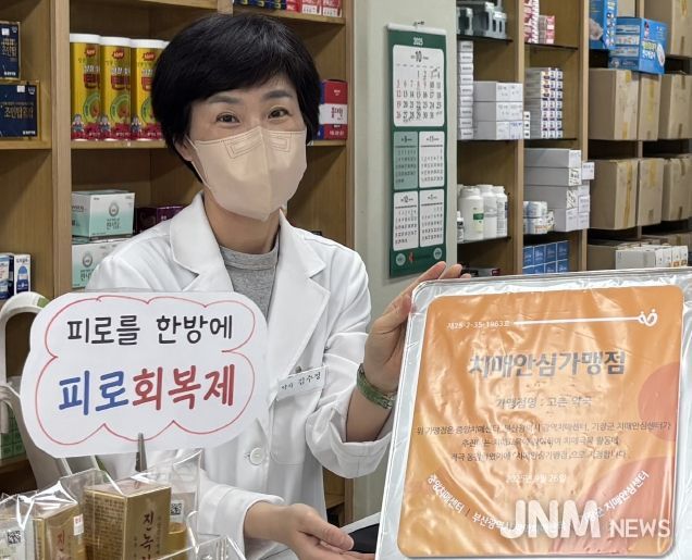 철마면 고촌약국 김수정 대표가 기장군 치매안심가맹점 지정 현판을 전달받고 있다