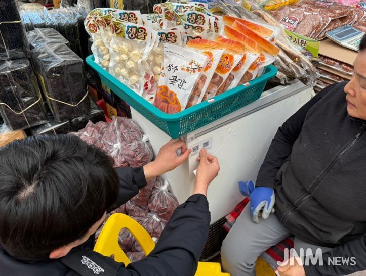 1. 강진소방서 직원이 겨울철 기간 자율안전점검 QR코드를 보이기 쉬운곳에 부착하고 있다.