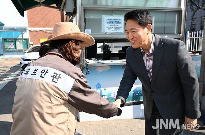 오세훈 서울시장이 13일 서울 소재 초등학교에서 학교보안관과 인사를 나누고 있다.